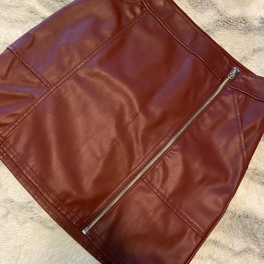 Maroon leather skirt with zipper.